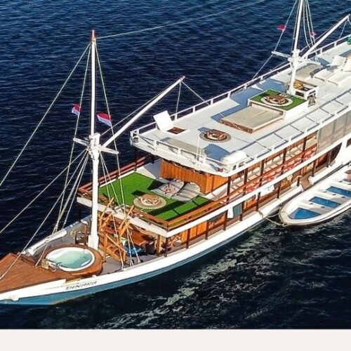 Kapal Dinara Superior Class Phinisi untuk sailing komodo 3 hari difoto dari udara di atas laut biru